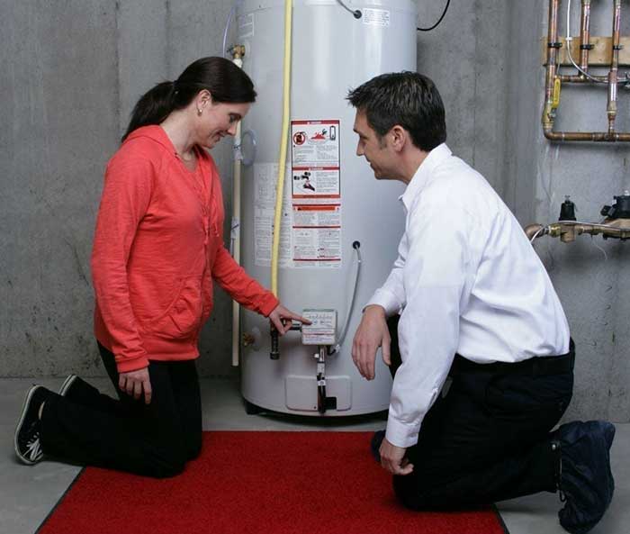 man and woman inspecting the water heater