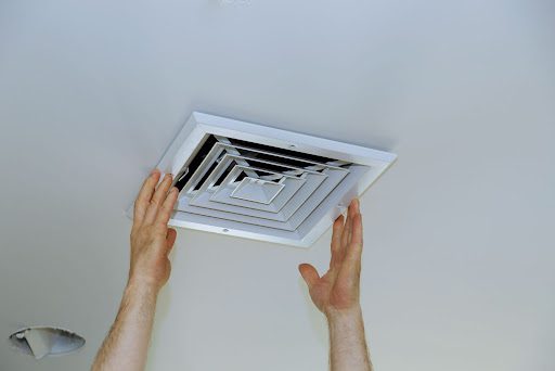 Two hands about to change vent cover